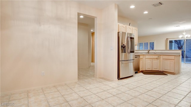 kitchen featuring sink, appliances with stainless steel finishes, a notable chandelier, light brown cabinetry, and kitchen peninsula