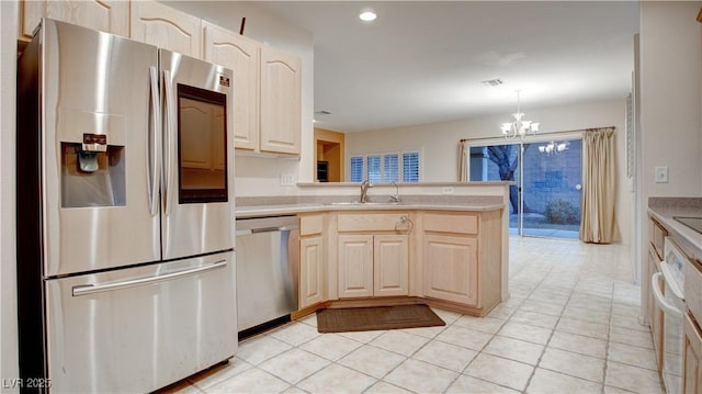 kitchen with appliances with stainless steel finishes, pendant lighting, sink, a notable chandelier, and kitchen peninsula