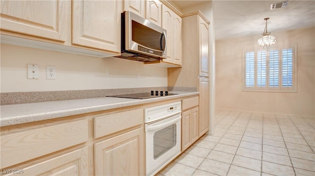 kitchen featuring light brown cabinetry, light tile patterned floors, black electric cooktop, pendant lighting, and oven