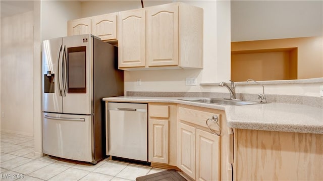 kitchen featuring light brown cabinetry, sink, light tile patterned floors, and stainless steel appliances