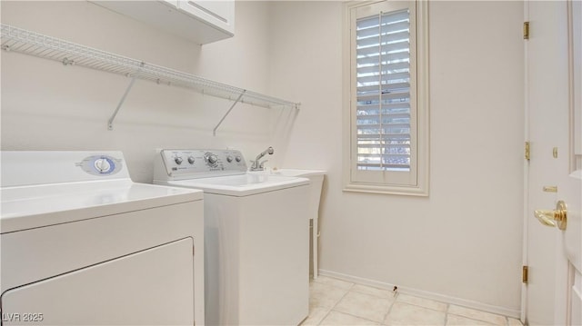 clothes washing area with cabinets, light tile patterned flooring, and separate washer and dryer