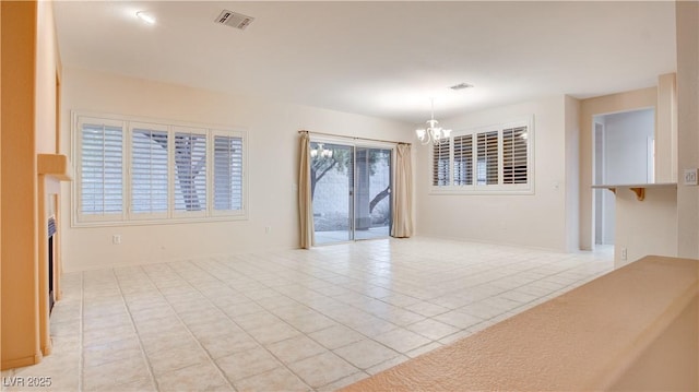 tiled spare room with a chandelier