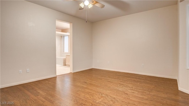 empty room with hardwood / wood-style floors and ceiling fan