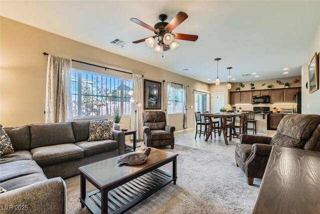 tiled living room with ceiling fan