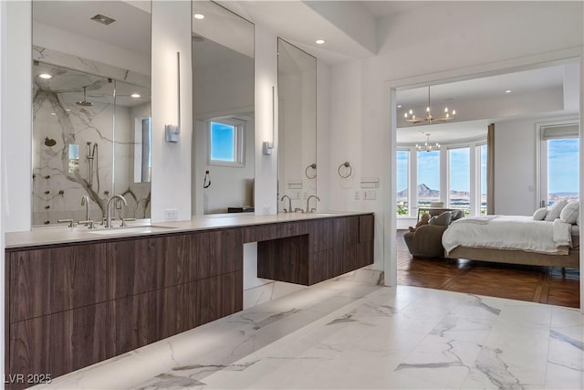 bathroom with an inviting chandelier, vanity, and walk in shower