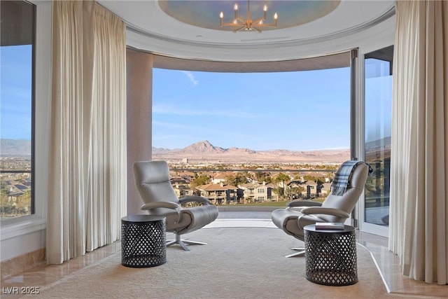 sitting room featuring floor to ceiling windows, a mountain view, and a notable chandelier