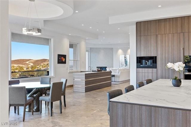 interior space with pendant lighting, a breakfast bar, a mountain view, and oven