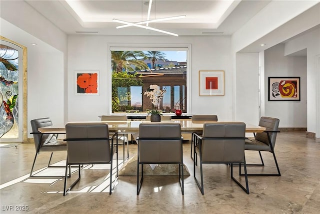 dining space with a raised ceiling