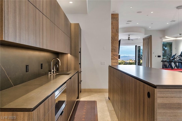 kitchen featuring sink, pendant lighting, dishwashing machine, and ceiling fan