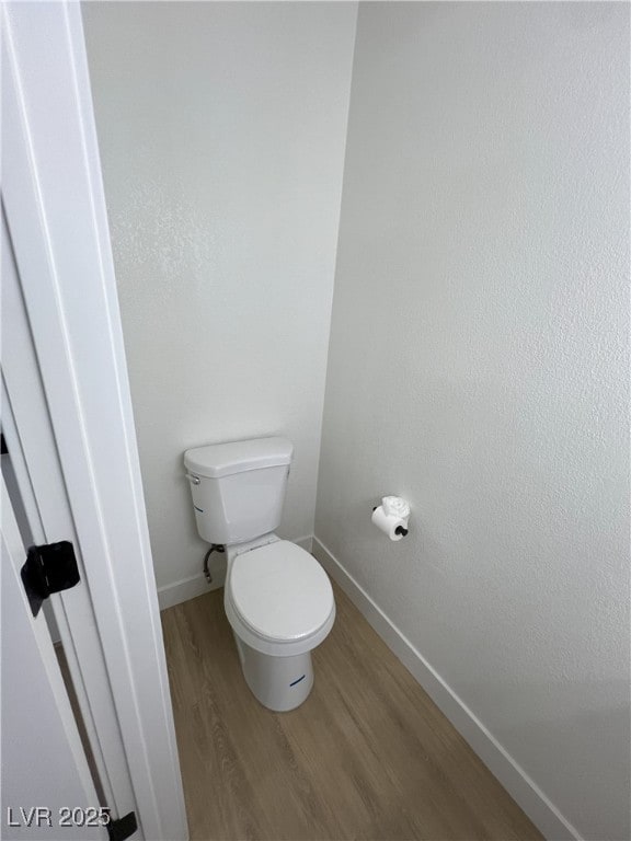 bathroom with hardwood / wood-style floors and toilet