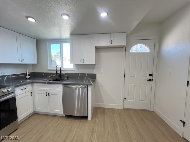 kitchen with white cabinetry, sink, and stainless steel appliances