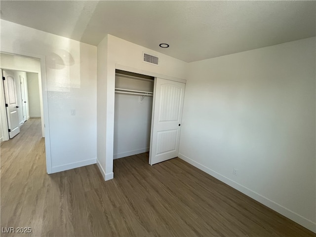 unfurnished bedroom featuring wood-type flooring and a closet