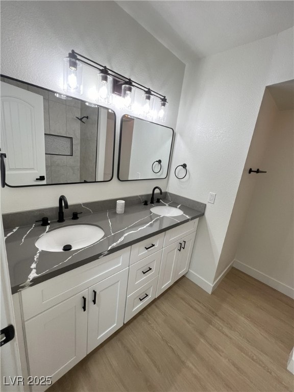 bathroom featuring wood-type flooring, vanity, and a shower