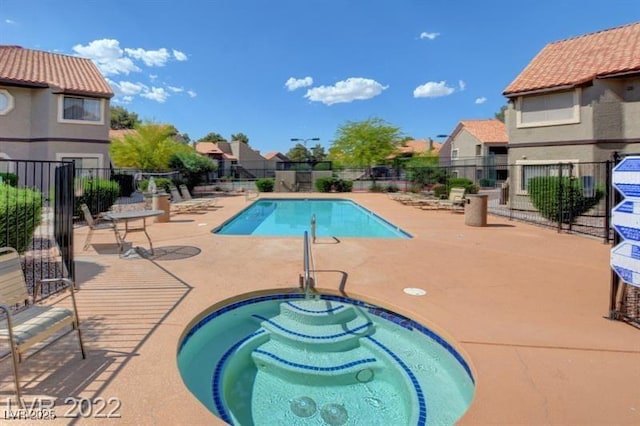 view of pool featuring a hot tub and a patio area