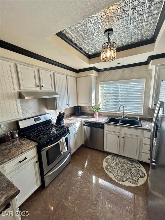 kitchen featuring pendant lighting, tasteful backsplash, sink, ornamental molding, and stainless steel appliances