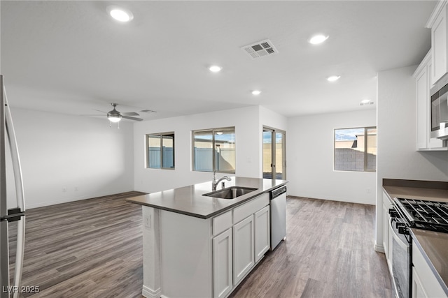 kitchen featuring stainless steel appliances, white cabinetry, sink, and an island with sink