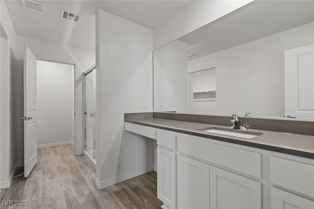 bathroom featuring vanity, hardwood / wood-style flooring, and a shower with shower door