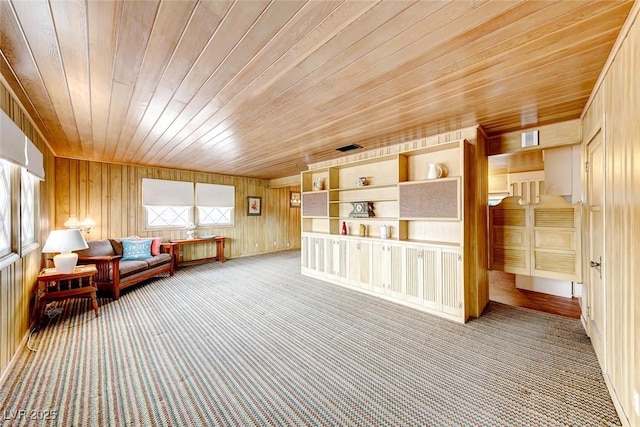 unfurnished room featuring carpet flooring, wooden walls, and wood ceiling