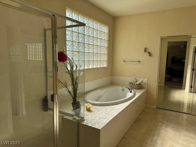 bathroom with plenty of natural light and separate shower and tub