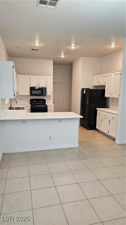 kitchen featuring black appliances, sink, white cabinets, light tile patterned floors, and kitchen peninsula