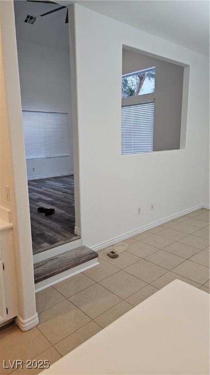 interior space featuring tile patterned flooring, visible vents, and baseboards