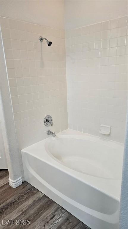 bathroom featuring wood finished floors and  shower combination