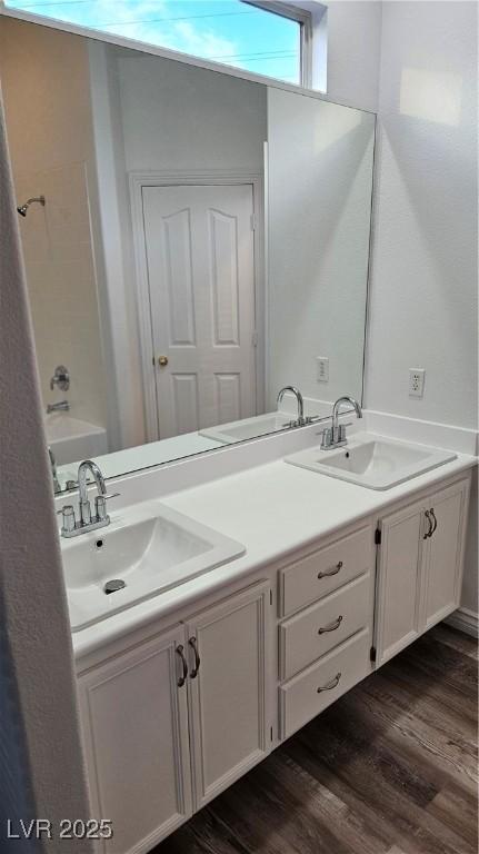 full bath featuring a sink, wood finished floors, and double vanity