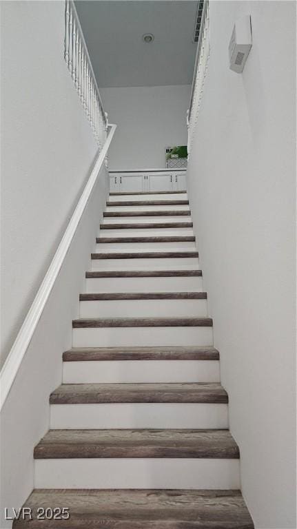 stairs featuring wood finished floors