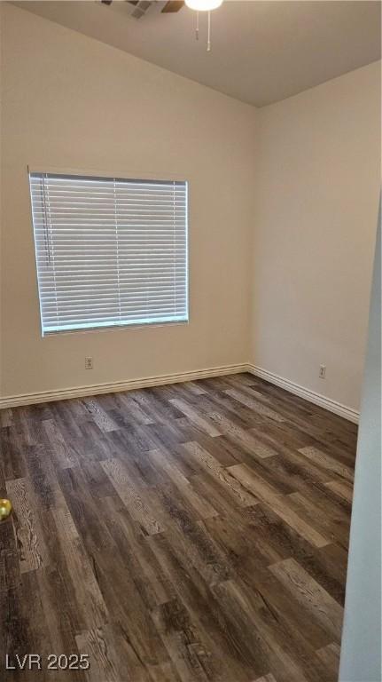 empty room with a ceiling fan, dark wood-style floors, and baseboards