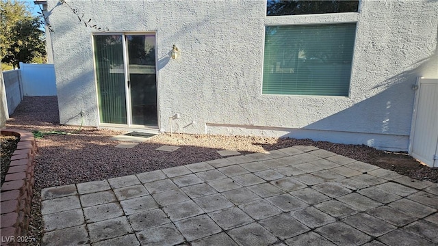 exterior space featuring stucco siding and fence