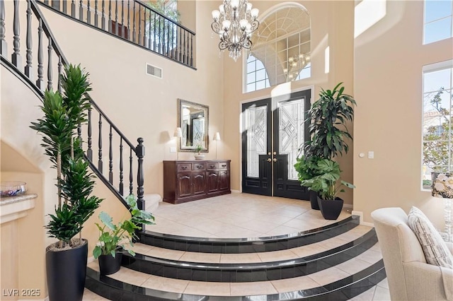 entrance foyer featuring french doors, a high ceiling, and a notable chandelier