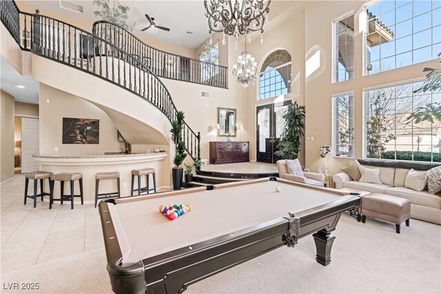 playroom featuring a notable chandelier, a towering ceiling, billiards, and light tile patterned flooring