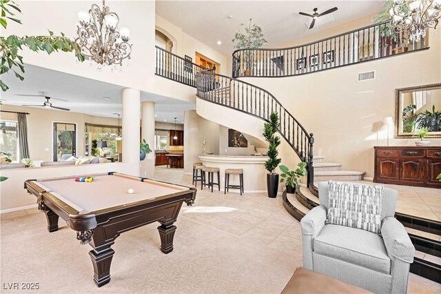 game room featuring ornate columns, a towering ceiling, ceiling fan with notable chandelier, billiards, and light tile patterned floors