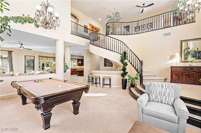 rec room featuring visible vents, pool table, decorative columns, ceiling fan with notable chandelier, and a towering ceiling