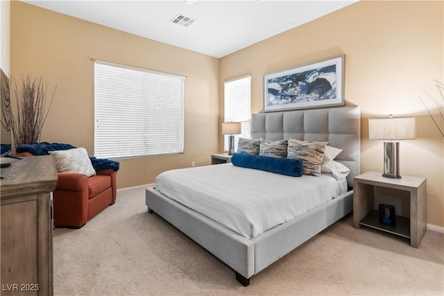 bedroom featuring multiple windows, light colored carpet, visible vents, and baseboards