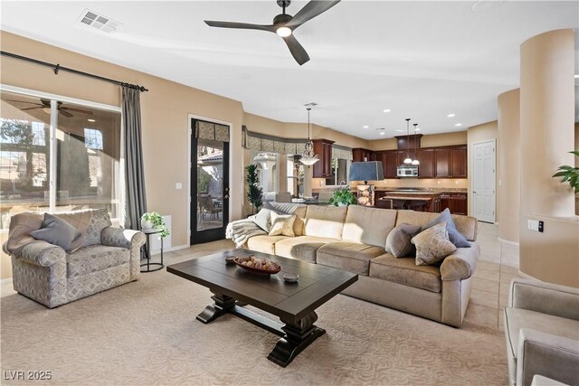 living room featuring a wealth of natural light, ceiling fan, and light tile patterned floors