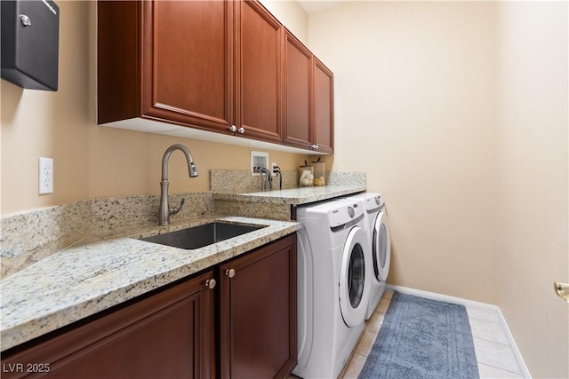 laundry area with baseboards, washing machine and dryer, light tile patterned floors, cabinet space, and a sink