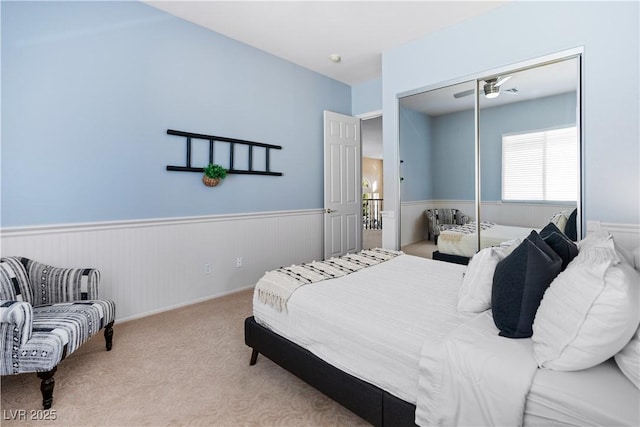 bedroom featuring a closet, carpet flooring, and wainscoting