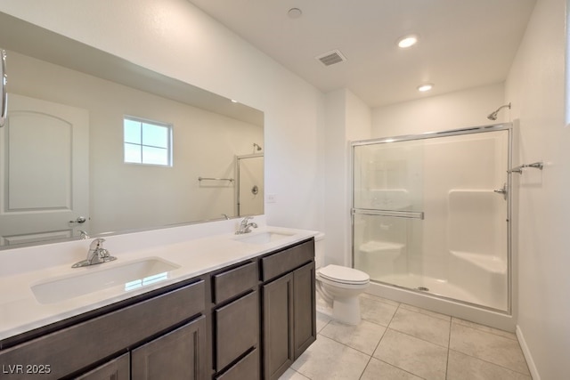 bathroom featuring vanity, toilet, a shower with shower door, and tile patterned flooring