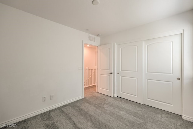 unfurnished bedroom featuring a closet and light carpet