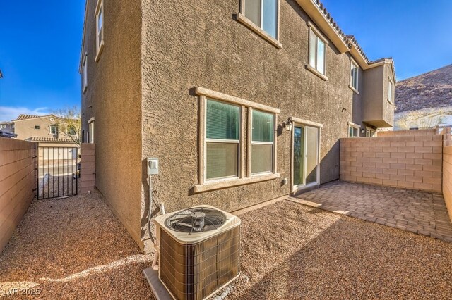 view of home's exterior with cooling unit and a patio