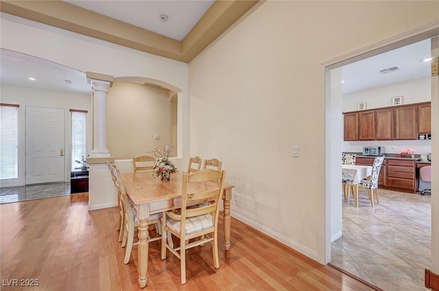 dining room featuring light hardwood / wood-style floors and decorative columns