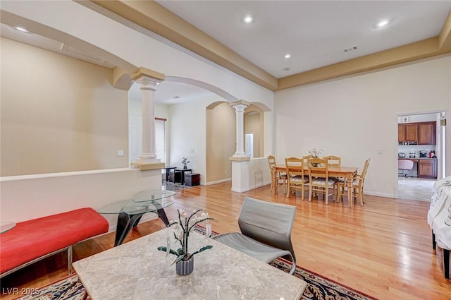 living room with decorative columns and light wood-type flooring