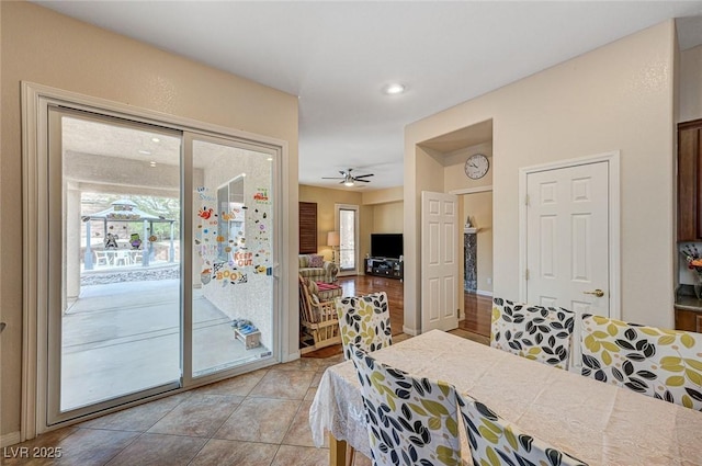 tiled dining space with a wealth of natural light and ceiling fan