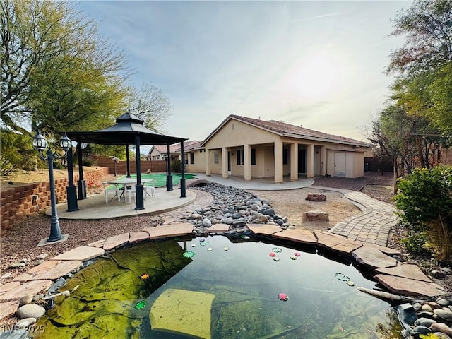 back of house featuring a gazebo, an outdoor fire pit, and a patio area