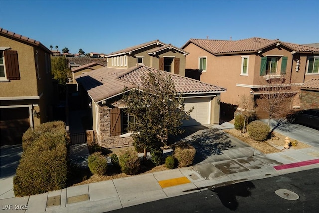 mediterranean / spanish house featuring concrete driveway, stone siding, a tile roof, a residential view, and stucco siding