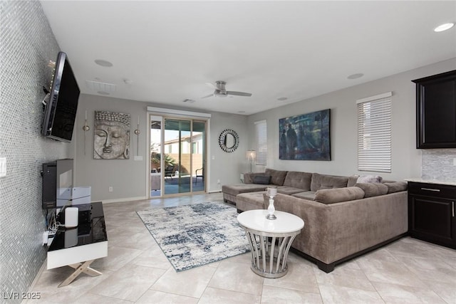 living room featuring baseboards, ceiling fan, an accent wall, light tile patterned flooring, and recessed lighting