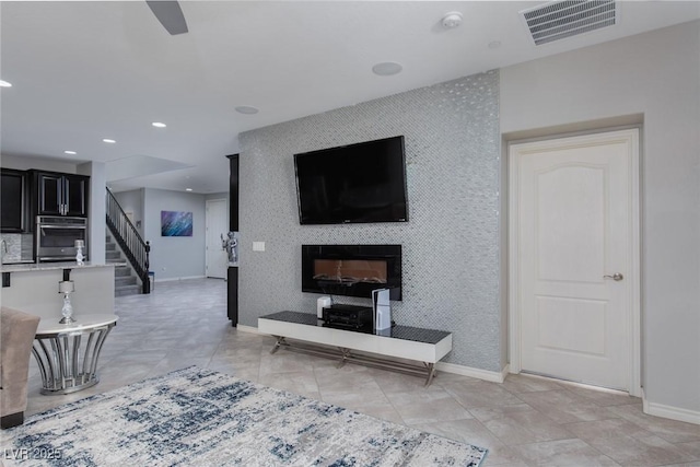 living area featuring stairway, baseboards, and visible vents