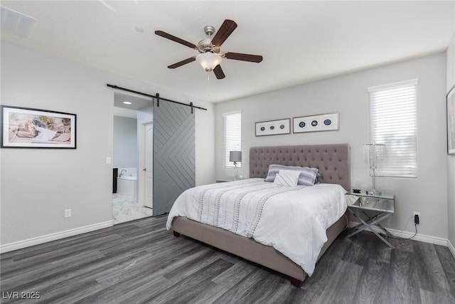 bedroom featuring a barn door, wood finished floors, visible vents, and baseboards