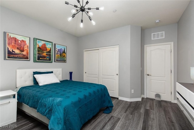 bedroom with a notable chandelier, dark wood-style flooring, visible vents, baseboards, and a closet